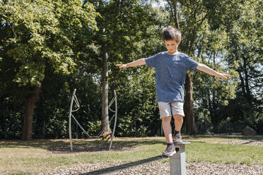 Junge balanciert auf einer Metallstruktur auf einem Spielplatz - ELMF00002