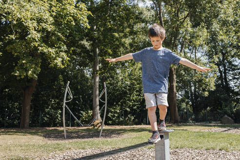 Boy balancing on metal structure in playground - ELMF00002