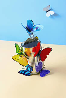 Studio shot of paper craft butterflies opening can of food - RDTF00031