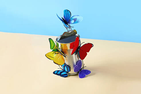 Studio shot of paper craft butterflies opening can of food - RDTF00032