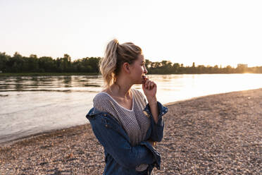 Thoughtful woman standing at beach - UUF31432
