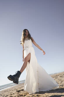 Junge Frau im weißen Hochzeitskleid am Strand - VEGF06255