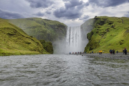 Island, Sudurland, Touristen besuchen den Wasserfall Skogafoss - RUEF04294