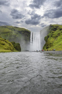 Island, Sudurland, Touristen besuchen den Wasserfall Skogafoss - RUEF04295