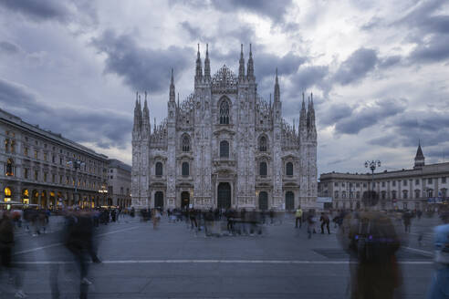 Italien, Lombardei, Mailand, Unscharfe Bewegung von Menschen zu Fuß vor dem Mailänder Dom in der Abenddämmerung - RUEF04310