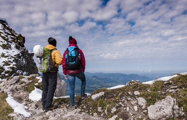 Hikers standing and looking at Bavarian Alps in Germany - UUF31458