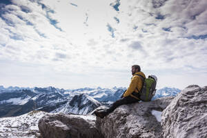 Rucksacktourist sitzt auf einem Berg in den Bayerischen Alpen, Deutschland - UUF31462