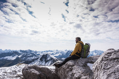 Backpacker sitting on mountain at Bavarian Alps, Germany - UUF31462