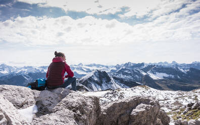 Junger Wanderer sitzt auf einem Berg in den bayerischen Alpen, Deutschland - UUF31464