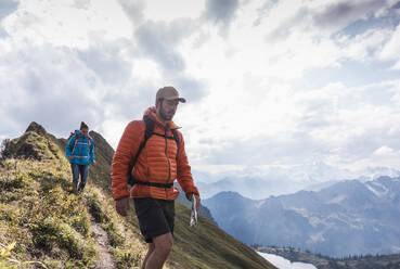 Wandererpaar beim Abstieg auf einem Berg in den bayerischen Alpen in Deutschland - UUF31475