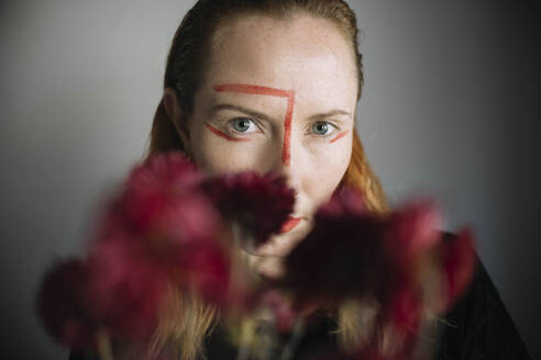 Ernste Frau mit Lippenstiftfleck im Gesicht vor grauem Hintergrund - ASHF00073