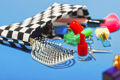 Studio shot of various cosmetics falling out of checked purse - RDTF00036