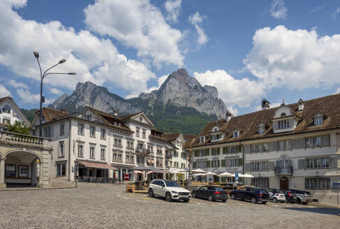 Geparkte Fahrzeuge in der Nähe des Hauptplatzes mit dem Gipfel des Grossen Mythen unter dem Himmel in der Zentralschweiz, Kanton Schwyz, Schweiz - MAMF02935