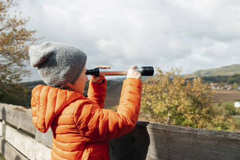 Junge mit Jacke und Blick durch ein Teleskop - ELMF00013