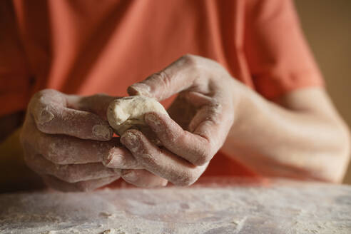 Senior woman making dough buns in kitchen at home - KVBF00031