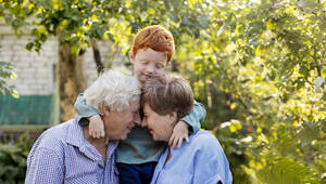 Glückliches älteres Paar mit Gesicht zu Gesicht in der Nähe des Enkels im Garten - MBLF00278