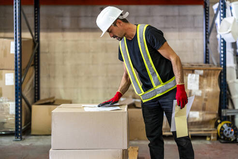 Worker examining checklist at warehouse - DLTSF03784