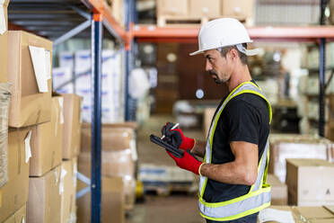 Worker taking inventory on tablet PC at warehouse - DLTSF03789