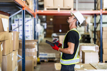 Worker taking inventory with tablet PC at warehouse - DLTSF03790