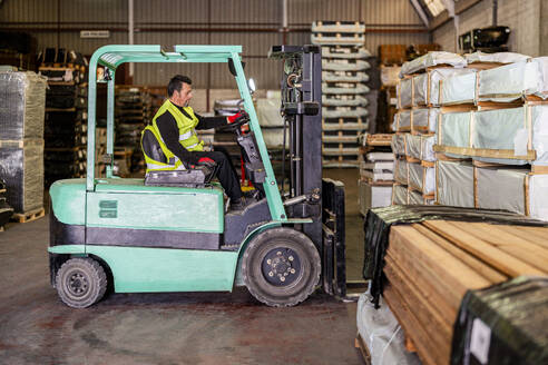 Worker operating forklift at warehouse - DLTSF03794