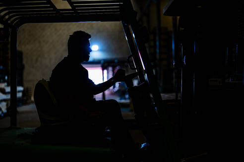 Worker operating forklift at warehouse - DLTSF03819