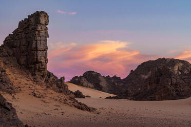 A breathtaking view of Djanet with towering rock formations under a colorful sunset sky - ADSF52984
