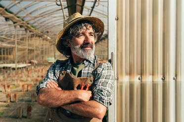 Farmer senior man working in his farm and greenhouse. Concept about agriculture, farn industry, and healthy lifestyle during seniority age - DMDF09919