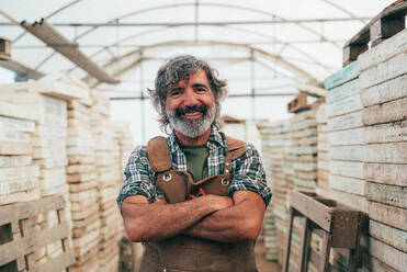 Farmer senior man working in his farm and greenhouse. Concept about agriculture, farn industry, and healthy lifestyle during seniority age - DMDF09967