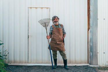 Ein älterer Landwirt bei der Arbeit auf seinem Bauernhof und in seinem Gewächshaus - ein Konzept für die Landwirtschaft, die Farnindustrie und eine gesunde Lebensweise im Alter - DMDF09969