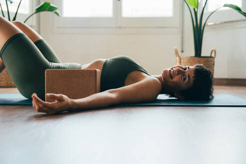 Schönes sportliches Mädchen beim Yoga-Training im Fitness-Studio. Junge Trainerin mit kurzen Haaren, die Yoga- und Acroyoga-Posen ausführt und sich für den Kurs aufwärmt. Konzepte für einen gesunden Lebensstil und Sportdisziplinen - DMDF09990