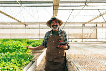 Farmer senior man working in his farm and greenhouse. Concept about agriculture, farn industry, and healthy lifestyle during seniority age - DMDF10029