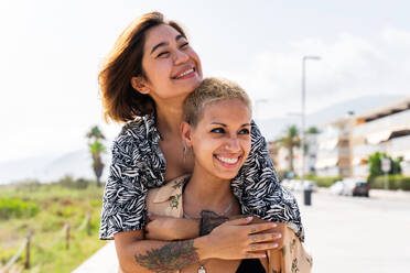 Beautiful multiethnic lesbian couple of lovers dating outdoors - LGBT people bonding and spending time together, concepts about LGBTQ community, diversity, love and lifestyle - DMDF10085