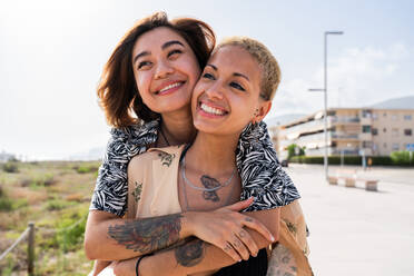 Beautiful multiethnic lesbian couple of lovers dating outdoors - LGBT people bonding and spending time together, concepts about LGBTQ community, diversity, love and lifestyle - DMDF10087
