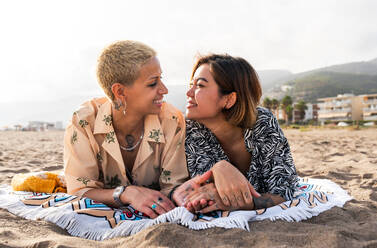 Beautiful multiethnic lesbian couple of lovers dating outdoors - LGBT people bonding and spending time together, concepts about LGBTQ community, diversity, love and lifestyle - DMDF10189