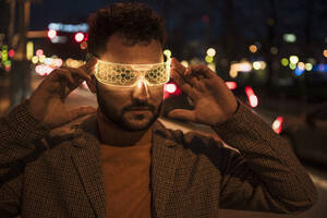 Man wearing smart glasses at night - UUF31517