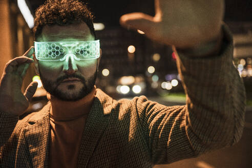 Man gesturing with green colored smart glasses - UUF31533