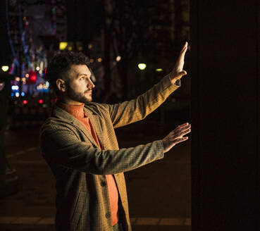 Man using touch screen kiosk at night - UUF31540