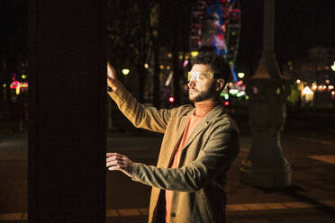 Man wearing smart glasses using touch screen kiosk on street - UUF31544