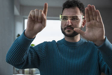 Man gesturing with smart glasses at home - UUF31581