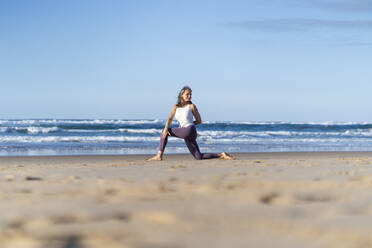 Ältere Frau übt Yoga in der Nähe des Meeres am Strand - JSIF00018