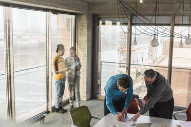 Multirassische Geschäftskollegen diskutieren in einer Besprechung im Büro - UUF31600