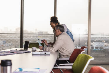 Business colleagues discussing over document in office - UUF31609