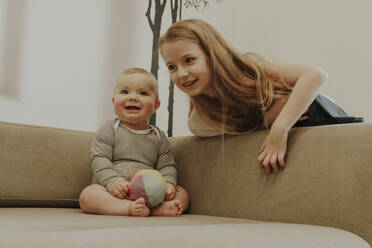 Smiling toddler with sister at home - OSF02428