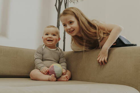 Smiling toddler with sister at home - OSF02428