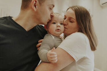 Parents kissing baby boy at home - OSF02431