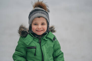 Lächelnder Junge mit warmer Kleidung im Winter - ANAF02730
