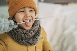 Verspielter Junge leckt Eiszapfen im Winter - ANAF02737
