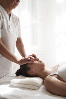 Therapeutin gibt Patientin im Behandlungsraum Akupressur-Massage - AAZF01633