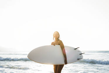 Junge Frau mit Surfbrett am Strand - AAZF01672