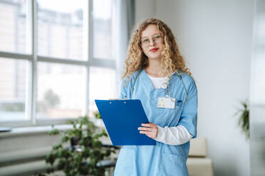 Doctor holding clipboard in hospital - MDOF01862